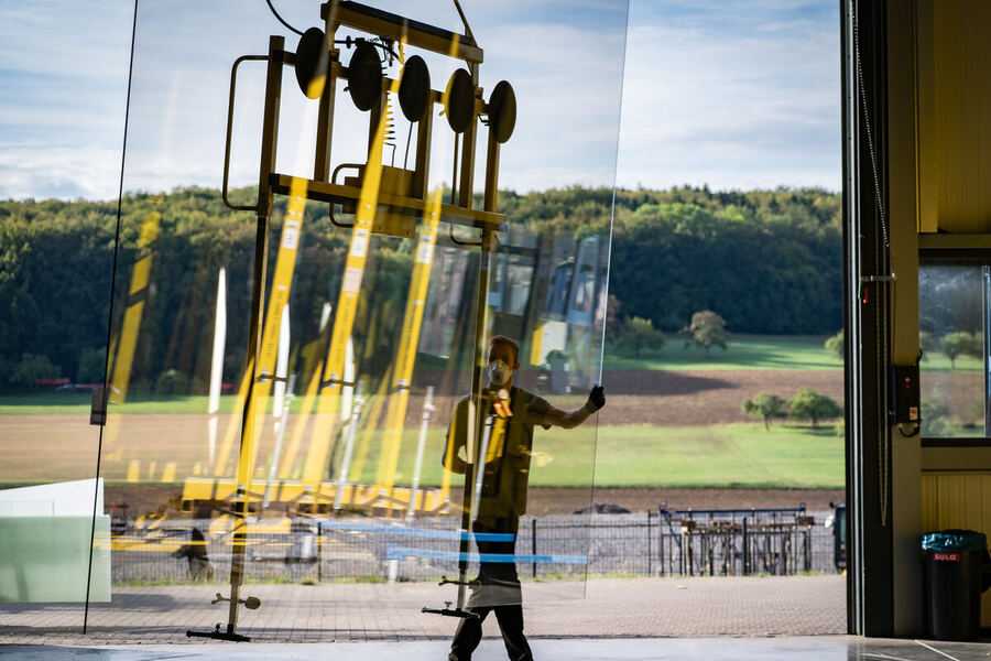 Glass panes for roofs and side elements are moved and glazed with a vacuum lifter in the same hall.