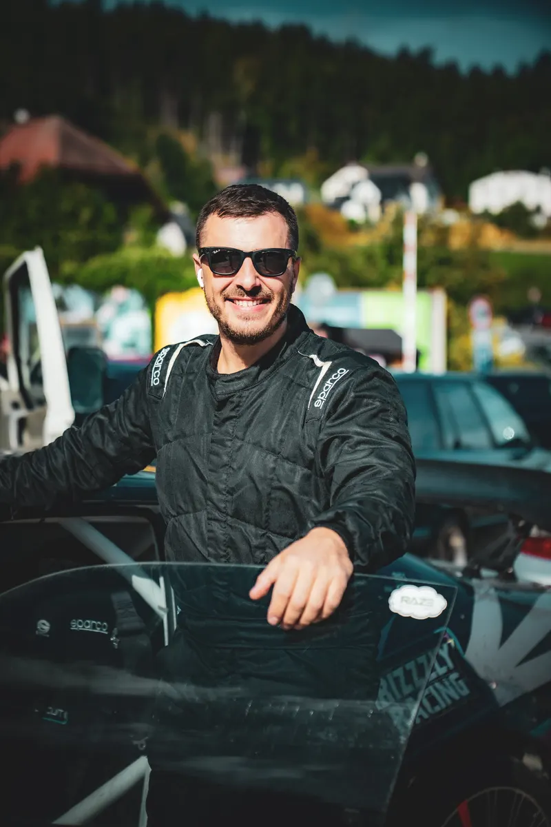 Denis Rem in a race suit at the open door of the drift car