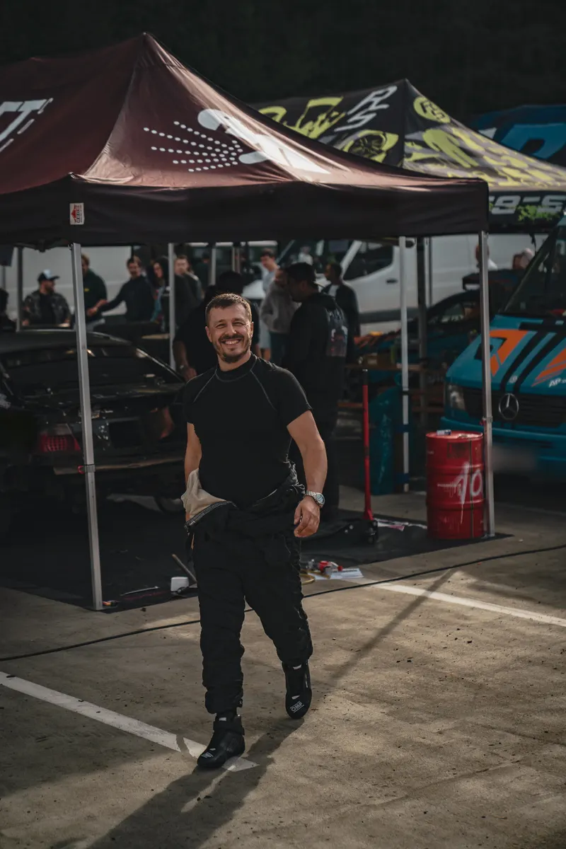 Denis Rem walking through the paddock past the team tents