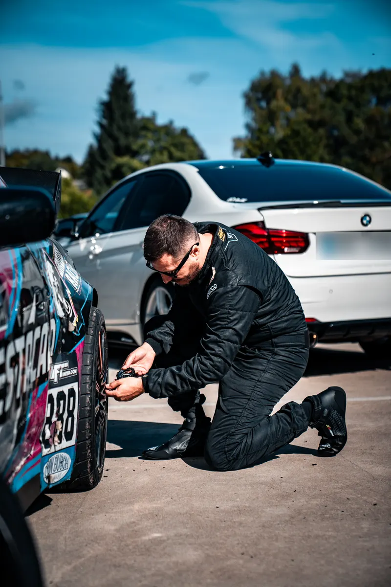 Denis Rem checks the pressure in the rear tyre of drift car number 888